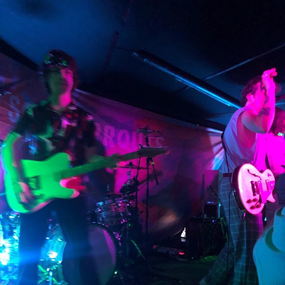 Two people playing guitars on stage at a concert.